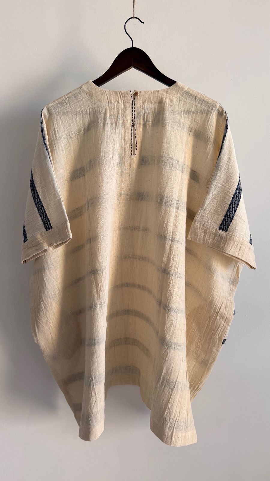 Back view of Cedar Dress in ivory ink handwoven cotton showing neckline slit and button detail