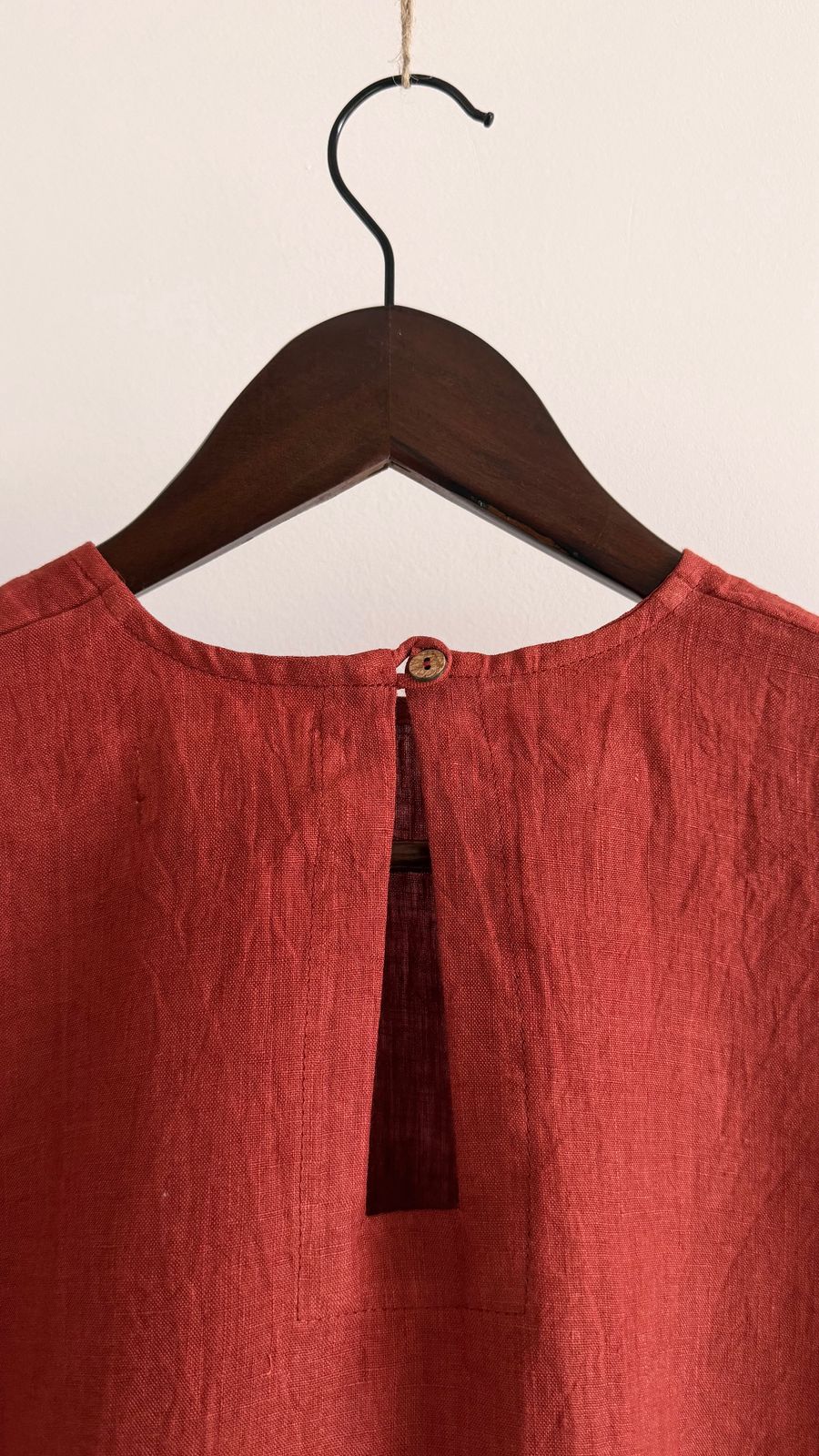 Minimal linen blouse in earthy rust red with short sleeves and back button detail