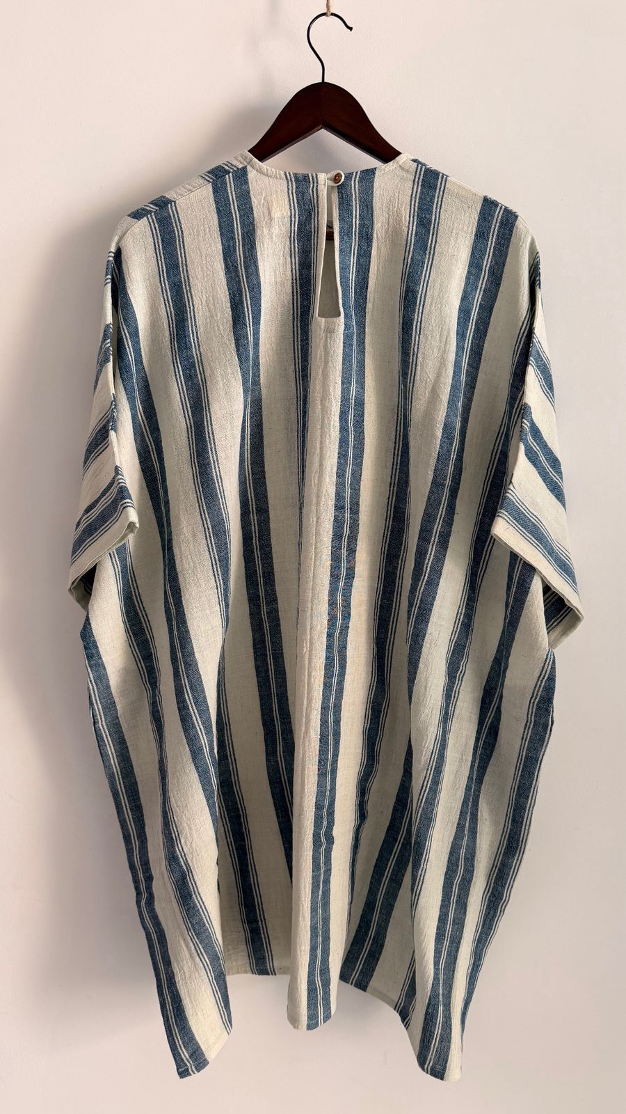 Back view of oat indigo striped Cedar dress with button closure detail.