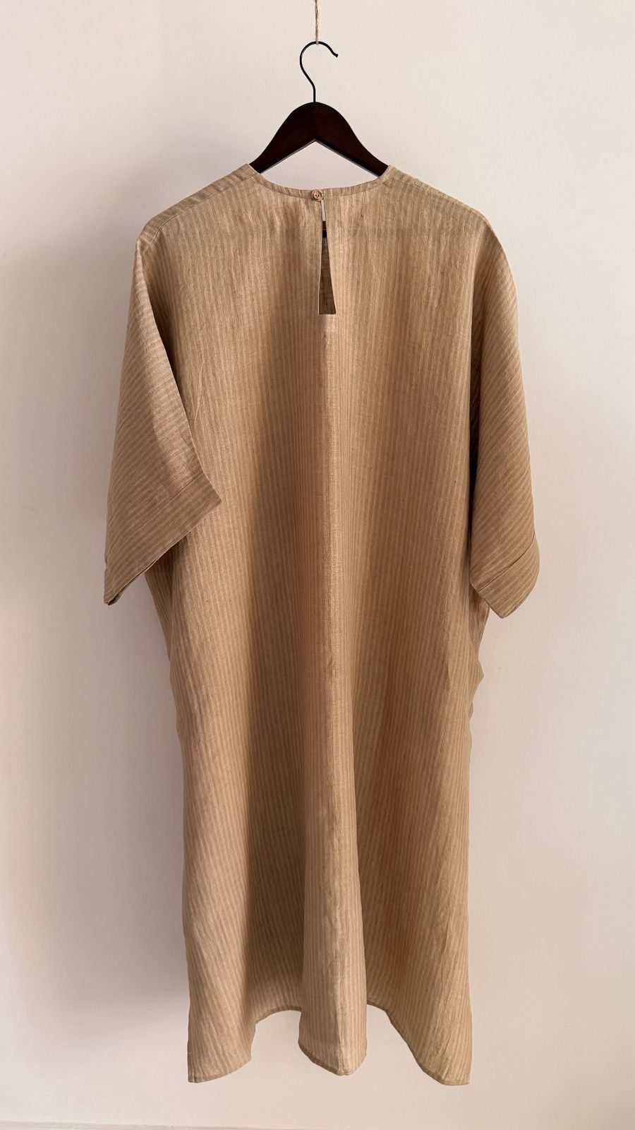 Sycamore dress in Kora Sand – back view showing relaxed silhouette and keyhole button closure.