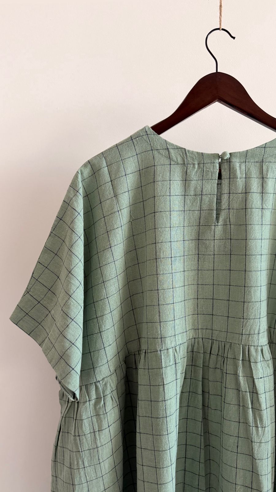 Back view of relaxed-fit cotton dress with button closure