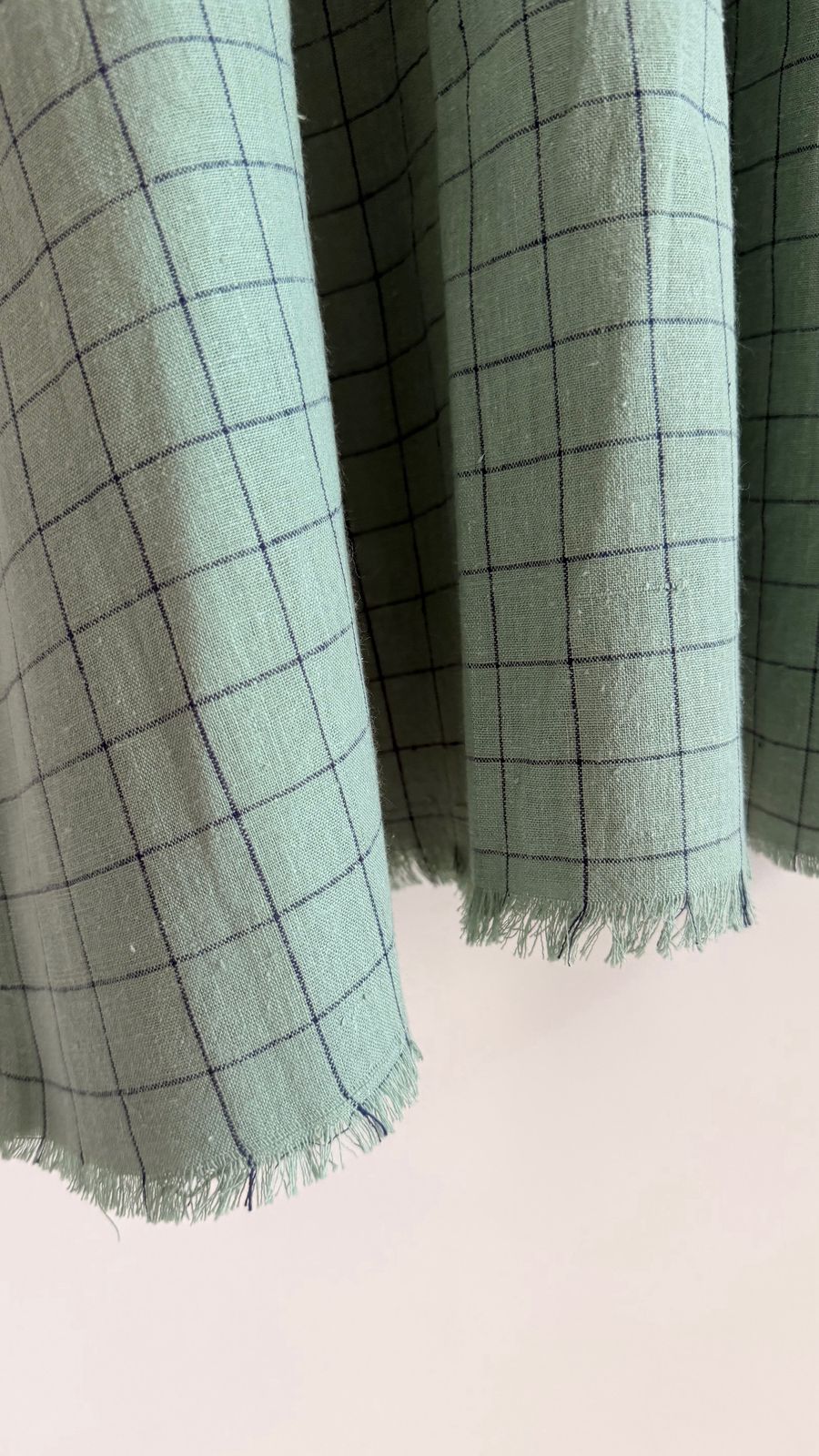 Close-up of frayed hem detail showing handwoven texture