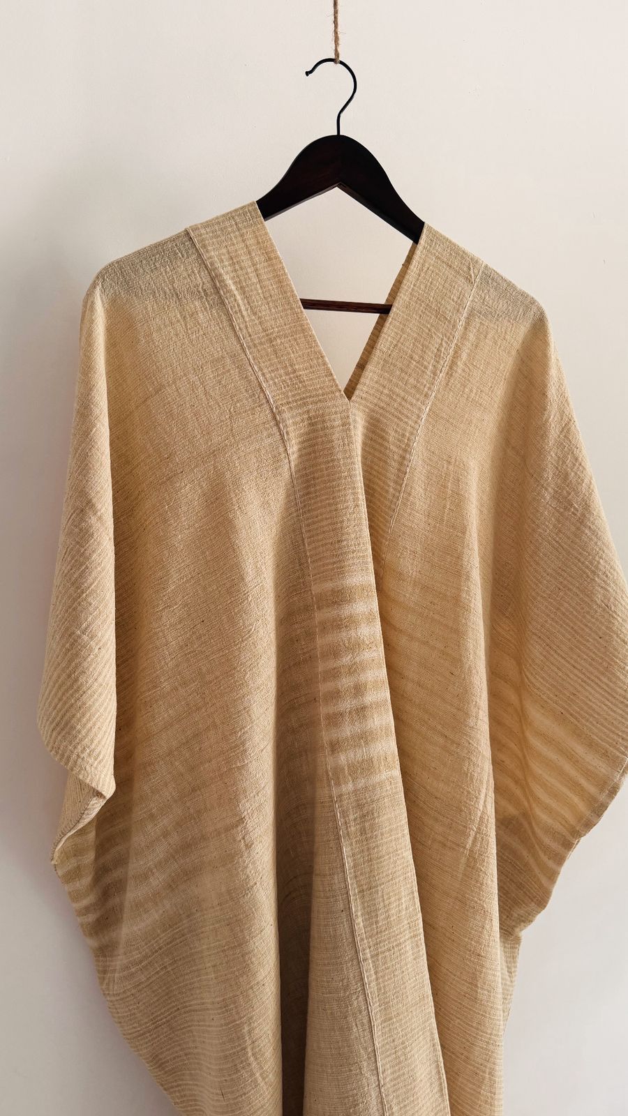 Back view of the Clove Kaftan in Oat Butter, highlighting the soft fall, subtle stripes, and natural texture of the handwoven cotton.