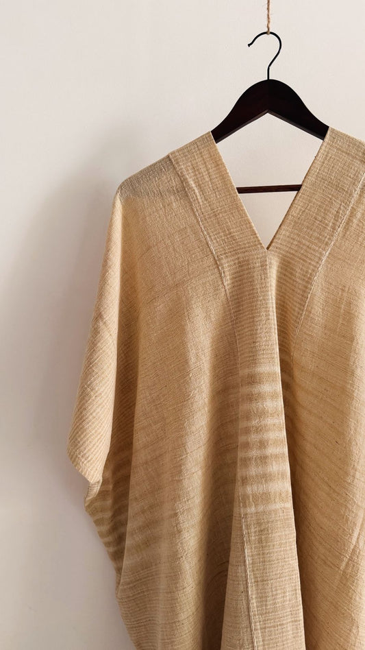 Side view of the Clove Kaftan in Oat Butter, showing its textured handwoven cotton, fluid drape, and relaxed silhouette.