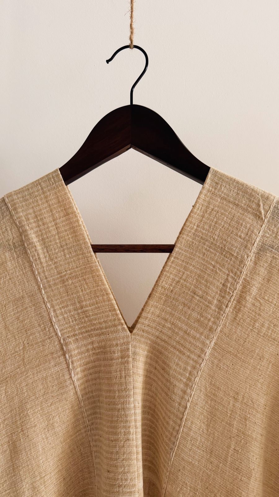 Close-up of the Clove Kaftan in Oat Butter, featuring delicate hand embroidery along the neckline and the textured striped weave.