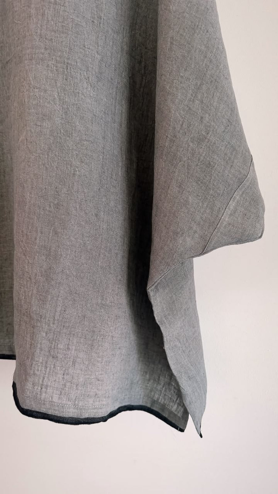 Close-up of the black contrast hem on the Elm ash grey handwoven linen top, showcasing the natural texture of the fabric.