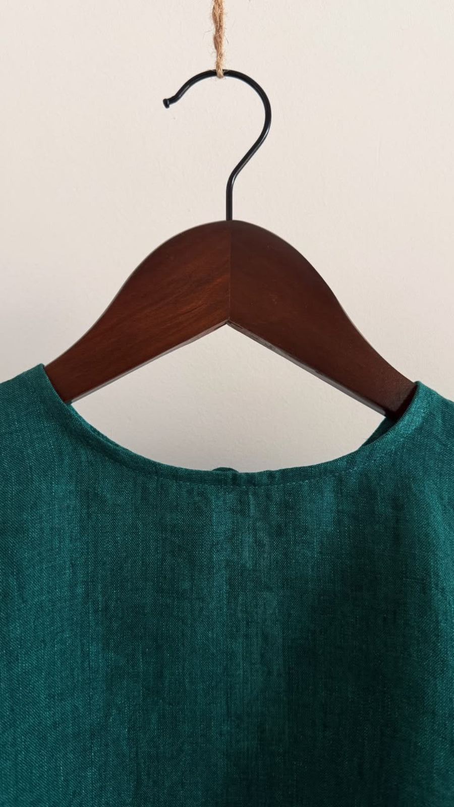 Close-up of the round neckline on the Elm forest green handwoven linen top, highlighting the natural weave of the fabric.