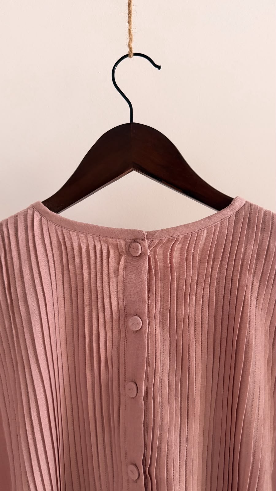 Close-up of fabric-covered buttons and hand-set pintucks on the back yoke.