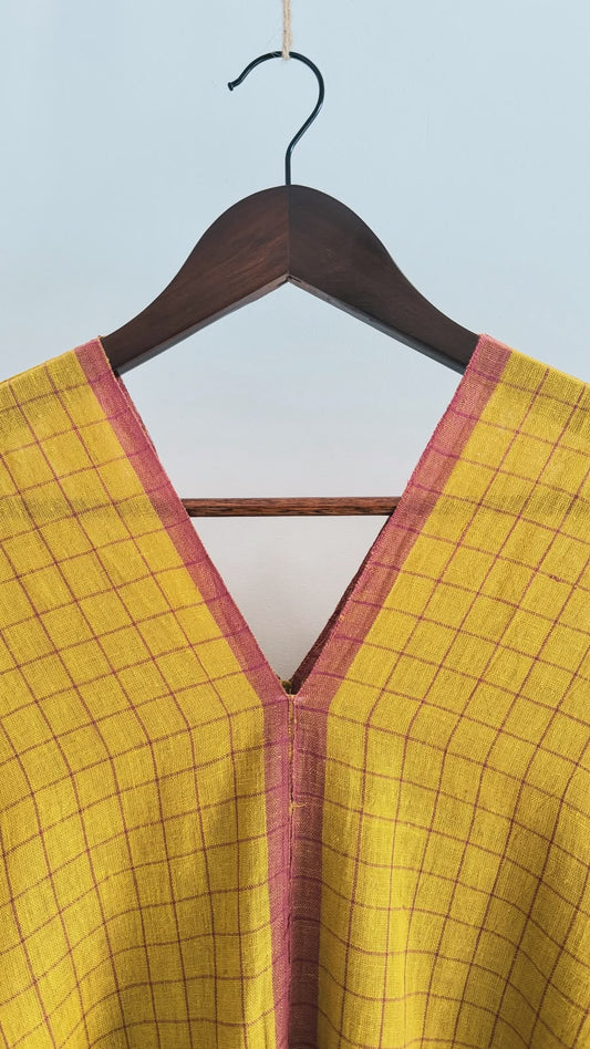 Close-up of the Sage handwoven cotton kaftan in earthen mustard featuring windowpane checks and a matching V-neck border.