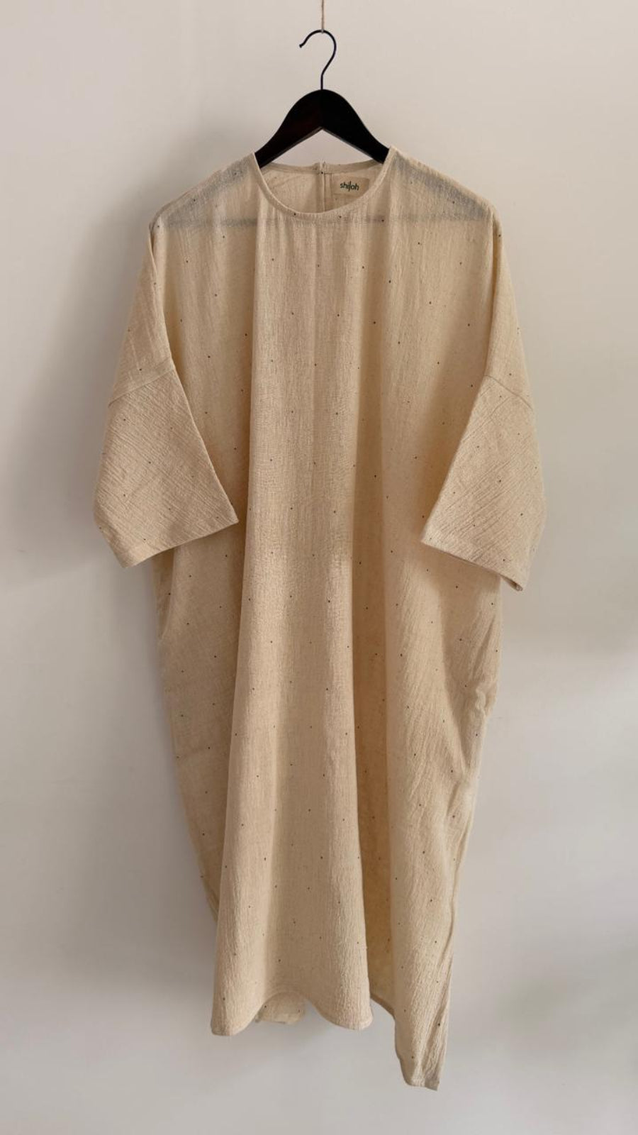 Full front view of relaxed handwoven cotton dress in kora with fine ink-speck detailing, dropped shoulders, and wide sleeves.