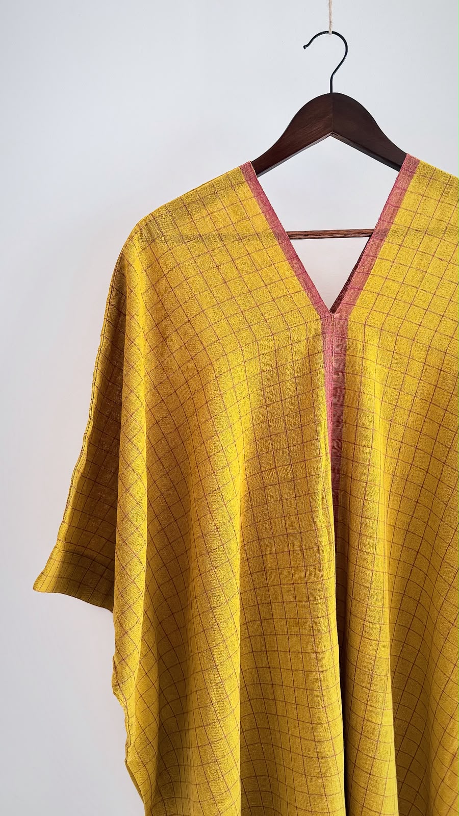 Handwoven cotton Sage kaftan in earthen mustard with windowpane checks, a matching woven V-neckline, and a relaxed drape.