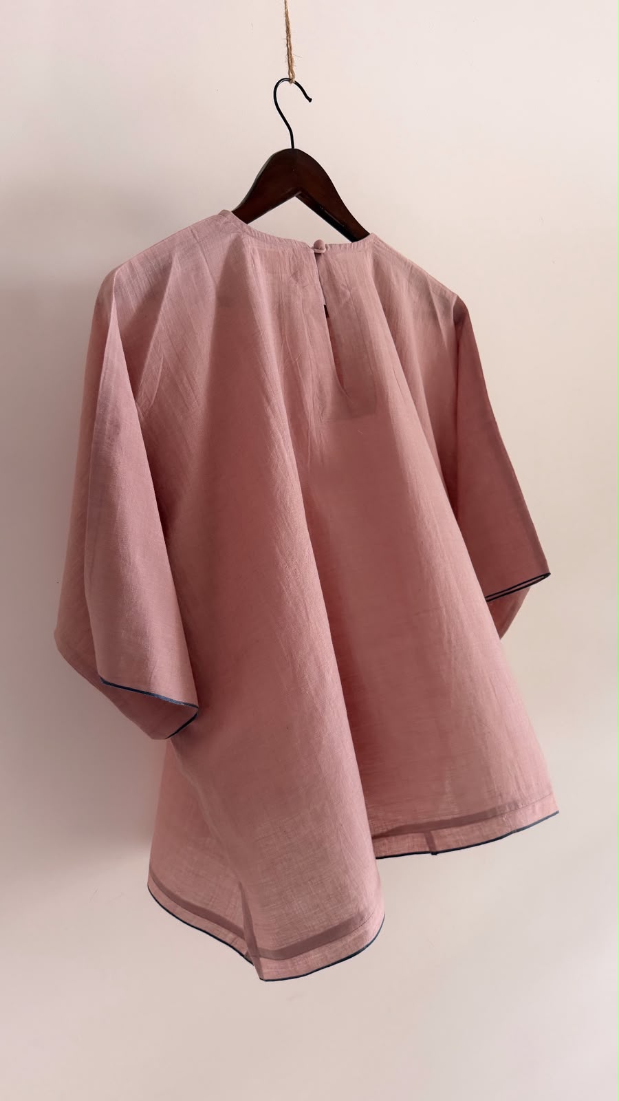 Back view of the Rue top in muted mauve handwoven cotton featuring a button closure and contrast navy selvedge.