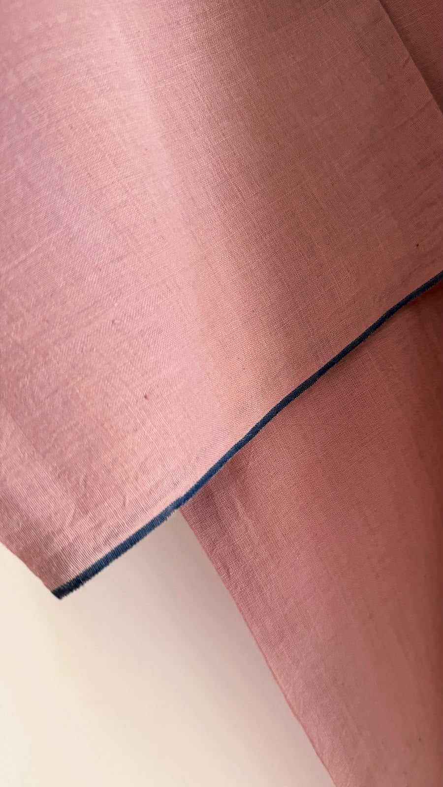 Close-up of the Rue top in muted mauve highlighting the handwoven cotton texture and contrast navy selvedge.