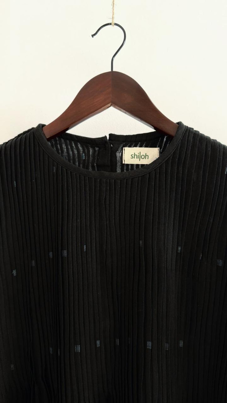 Close-up of Balm Coal Sky dress showing fine pleats and handwoven Jamdani motifs.