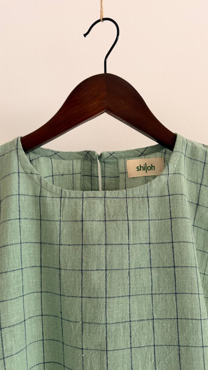 Front view of handwoven cotton top in pale teal with fine dark grid detailing, relaxed silhouette, and wide sleeves.