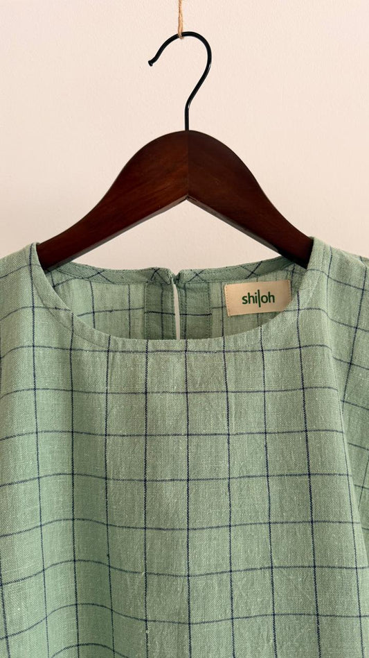 Front view of handwoven cotton top in pale teal with fine dark grid detailing, relaxed silhouette, and wide sleeves.